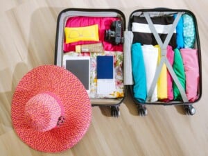Holiday Packing – Suitcase with Sun Hat and Camera